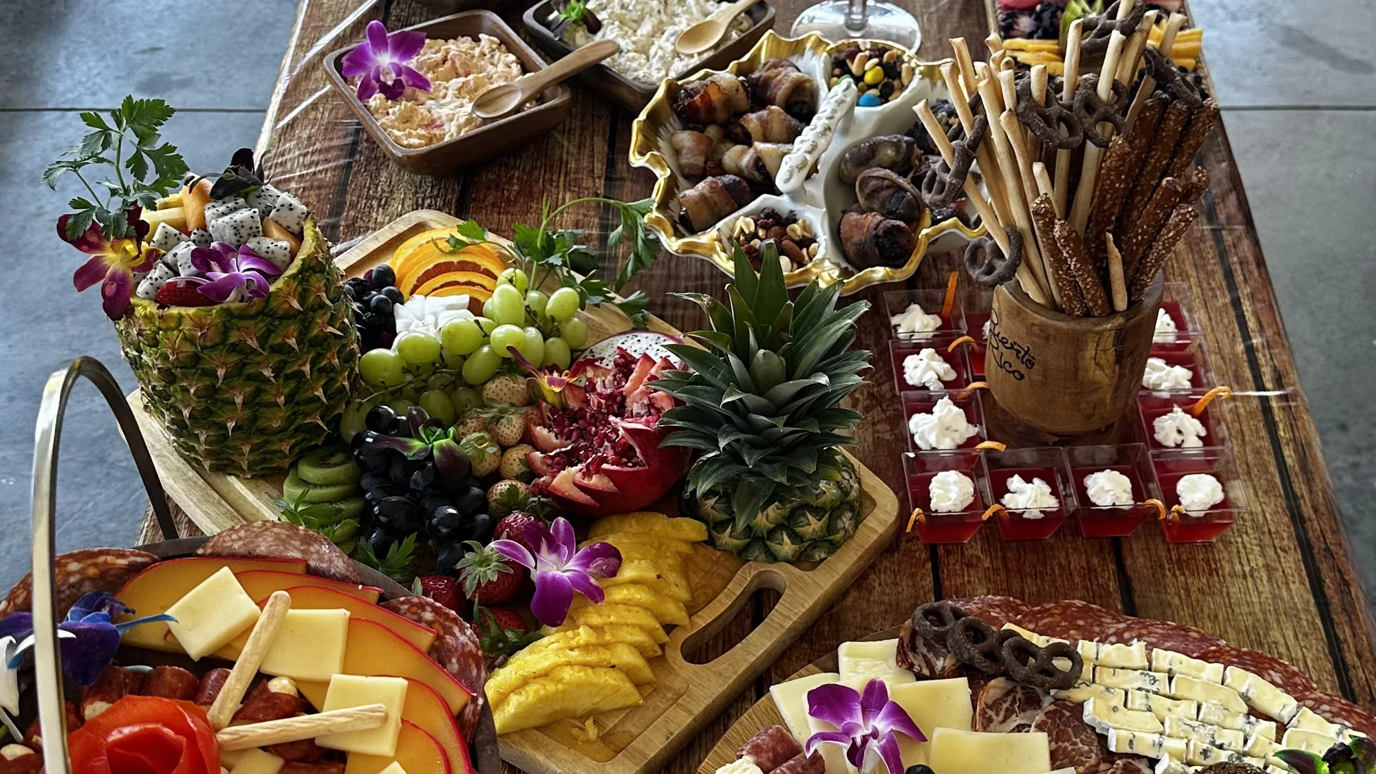 A composed Finca America catering table with fruit, charcuterie and individual bites